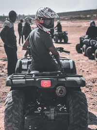 Rear view of man standing in car quads