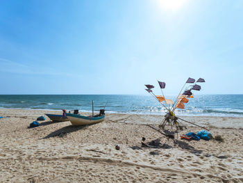 Fishing boat and flag fly in the wind on the beach with blue sky and sea water a beautiful seascape