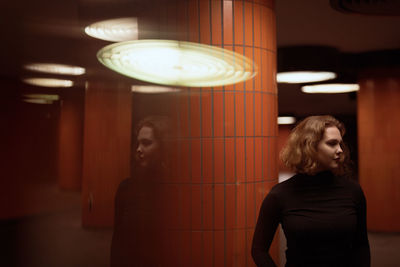 Double exposure of young woman standing by column