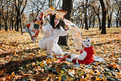 Happy family mother and little toddler baby daughter having fun together in autumn picnic