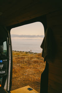 View of sea seen through car window