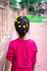 Rear view of girl standing against plants