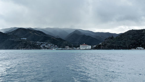 Scenic view of sea by buildings against sky