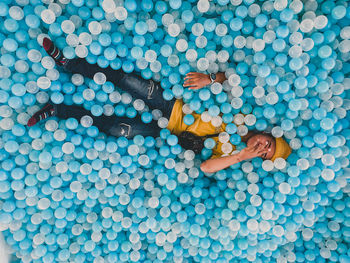 High angle view of man lying admist balloons