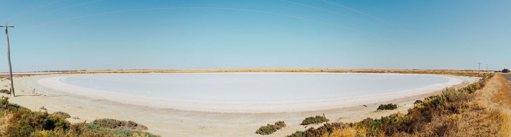 Panoramic view of desert against clear blue sky