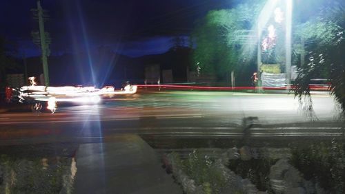 Illuminated road against sky at night