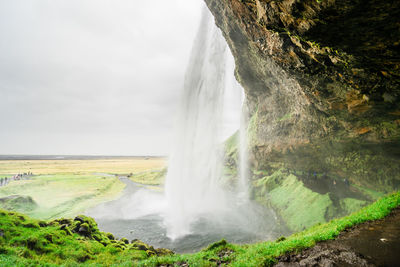 Scenic view of waterfall against sky