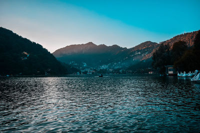 Scenic view of lake and mountains against blue sky