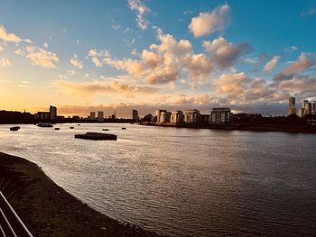 Panoramic view of sea and buildings against sky during sunset