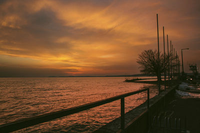 Scenic view of sea against dramatic sky during sunset