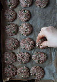 Cropped hand arranging food on baking sheet