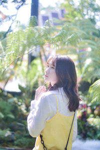 Side view of young woman looking through window