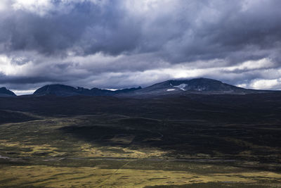 Scenic view of mountains against cloudy sky