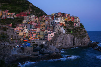 Townscape by sea against sky during sunset