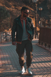 Full length of young man standing on footpath