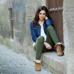 Portrait of young woman sitting on doorway