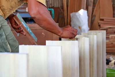 Midsection of man working on wood in workshop