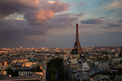 Aerial view of buildings in city against cloudy sky