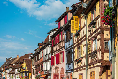 Low angle view of buildings in town against sky