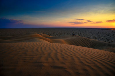 Scenic view of desert against sky during sunset