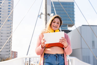 Curvy woman using digital tablet outdoors