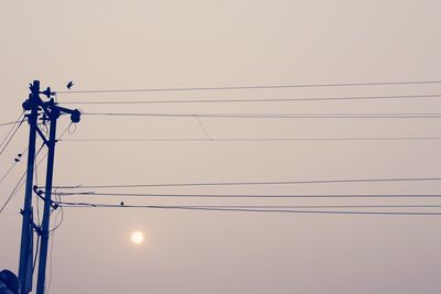 Low angle view of power lines against sky