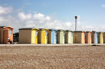 Beach huts against sky on sunny day