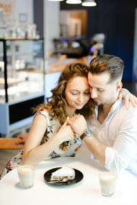 Couple embracing at cafe