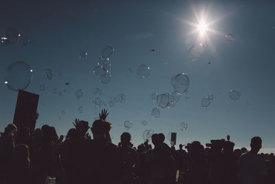 Bubbles over crowd at concert on sunny day