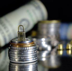 Close-up of padlock on stacked coins
