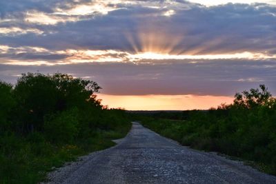 Road amidst landscape against dramatic sky