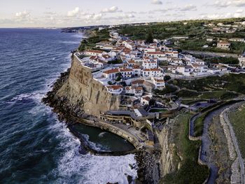 High angle view of buildings by sea against sky