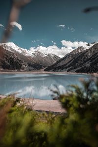 Scenic view of lake by mountains against sky