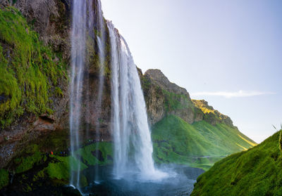 Scenic view of waterfall against sky