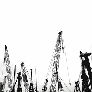 Low angle view of cranes against clear sky