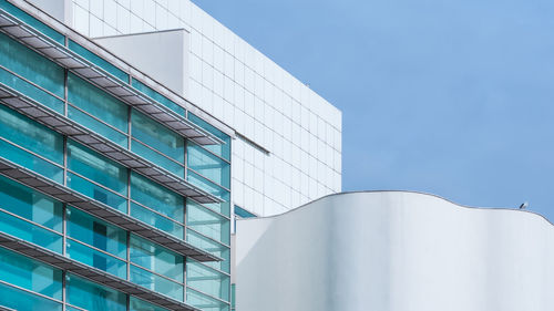 Low angle view of modern building against clear blue sky