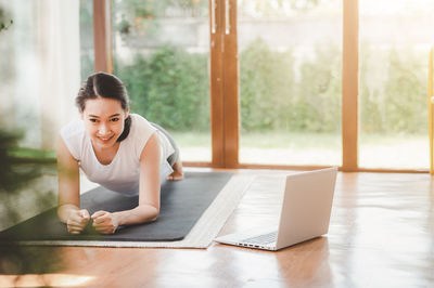 Portrait of smiling woman exercising at home
