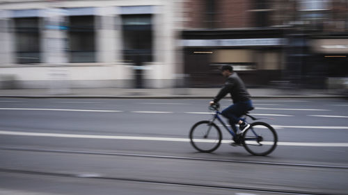 Man riding bicycle on street in city