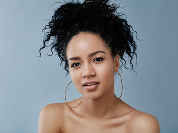 Close-up of young woman against blue sky