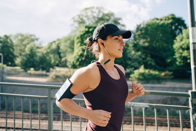 Woman looking away while standing against railing