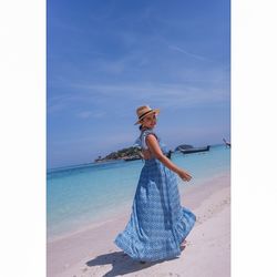 Full length portrait of woman wearing hat on beach against sky