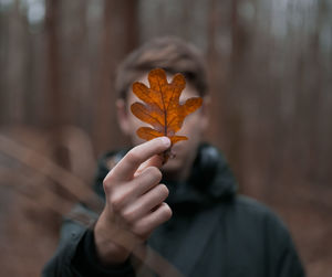 Close-up of teenage boy holding autumn leaf