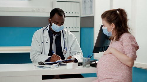 Female doctor examining patient in clinic