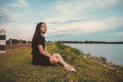 Portrait of woman sitting by lake 