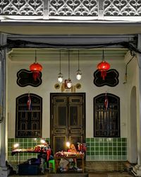 Illuminated lanterns hanging by building