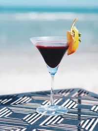 Close-up of cocktail glass in tray at beach