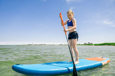 Girl paddleboarding in sea