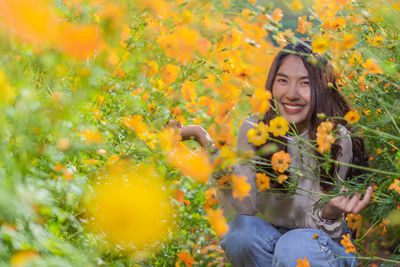 Portrait of smiling young woman with yellow flower