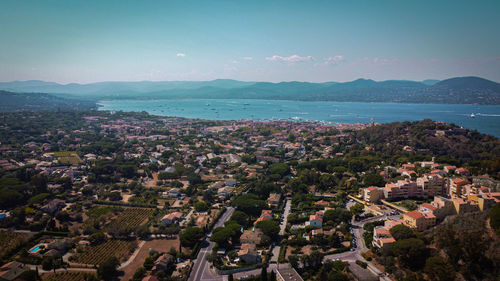 High angle view of townscape by sea against sky