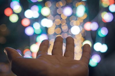 Defocused image of hand with illuminated lights